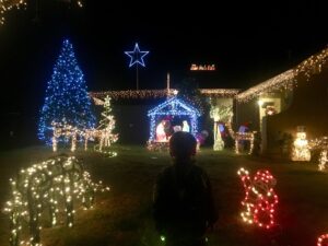 Toddler looking at house Christmas lights